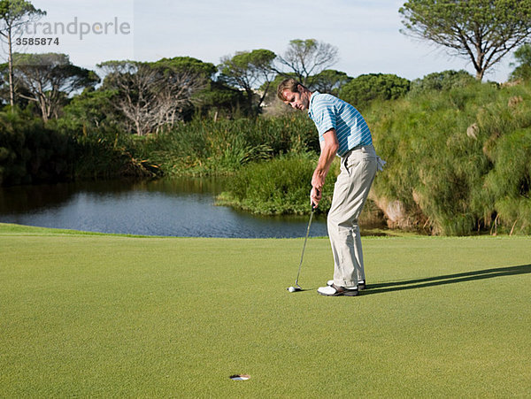 Mann spielt Golf auf dem Golfplatz