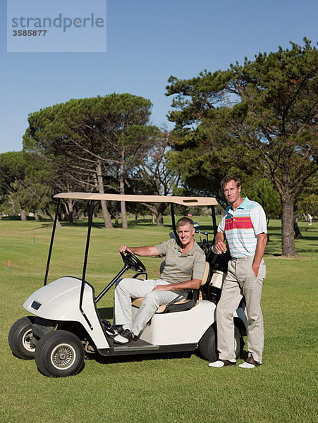 Zwei reife Männer im Golfwagen auf dem Golfplatz