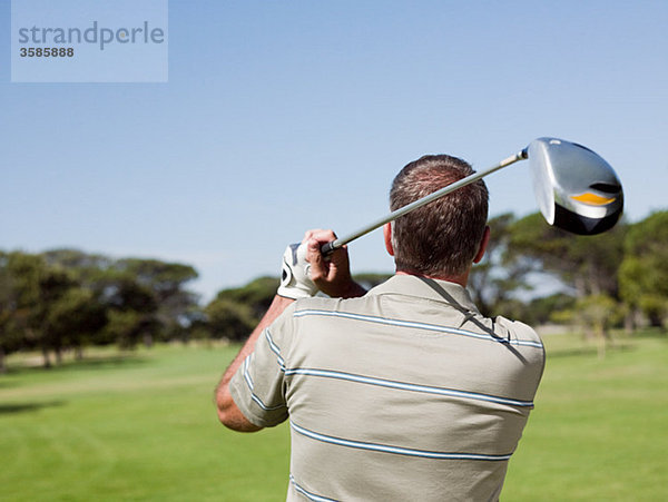 Mann spielt Golf auf dem Golfplatz