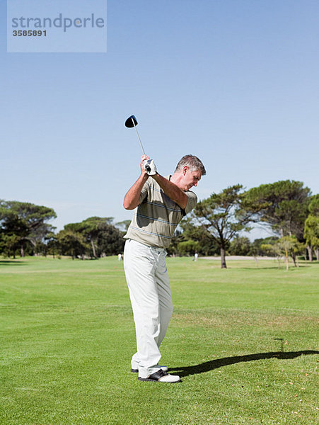 Mann spielt Golf auf dem Golfplatz