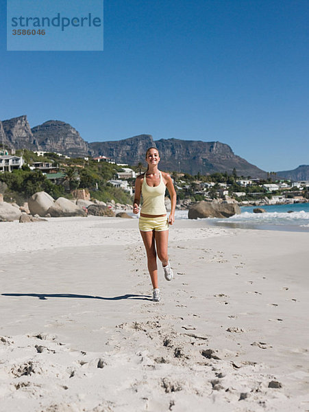 Junge Frau joggen am Strand