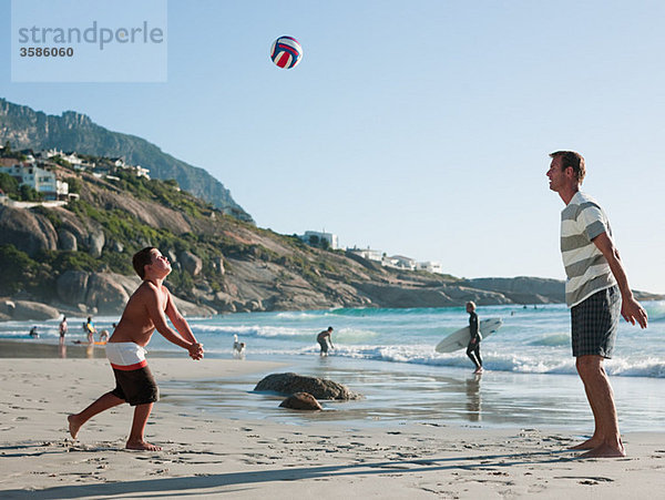 Vater und Sohn beim Ballspielen am Strand