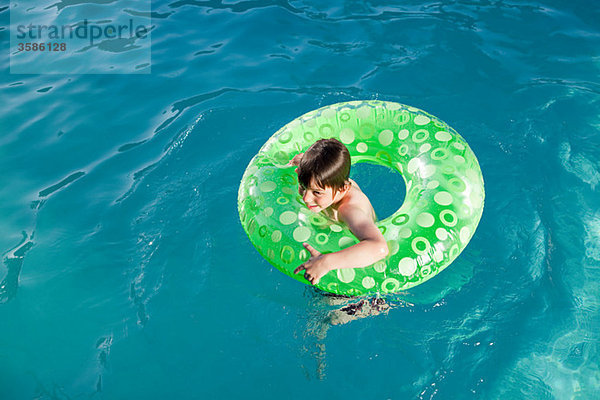 Junge im aufblasbaren Ring im Freibad