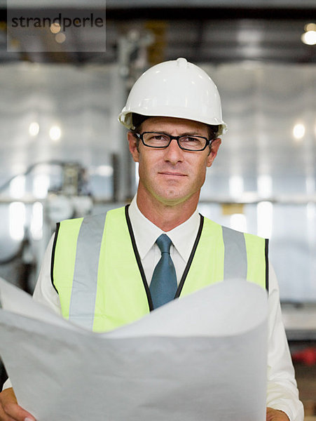 Erwachsener Mann mit Bauplan in der Fabrik  Portrait