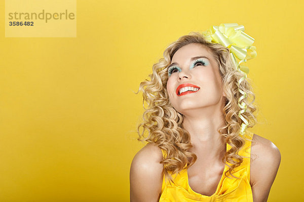 Junge blonde Frau vor gelbem Hintergrund