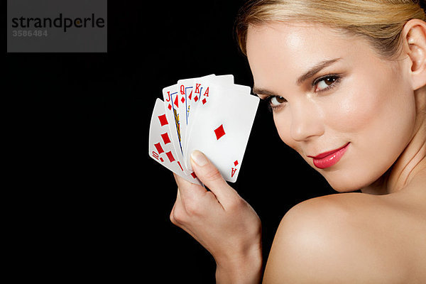 Junge blonde Frau beim Kartenspielen