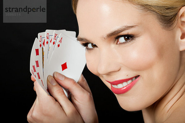 Junge blonde Frau beim Kartenspielen
