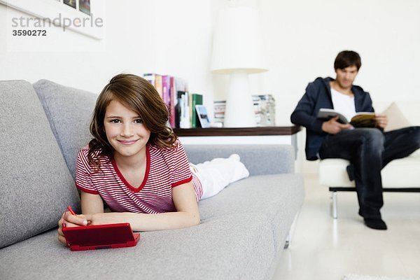 Mädchen spielt Videospiele Vater lesen