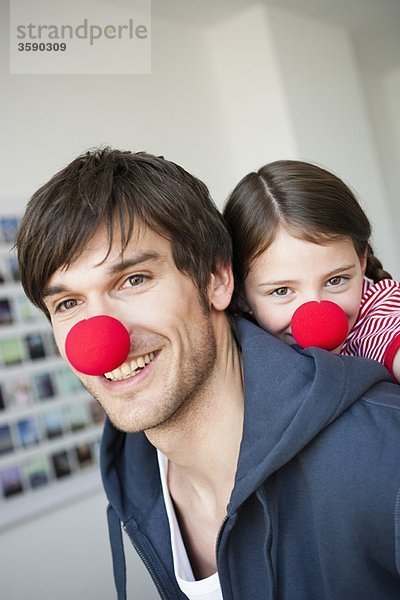 Vater und Mädchen mit roten Nasen