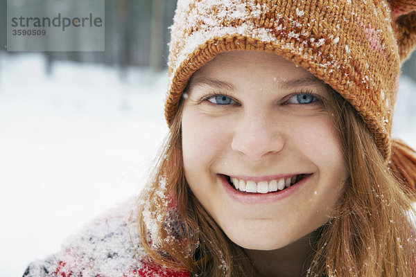 Lächelnde junge Frau im Schnee