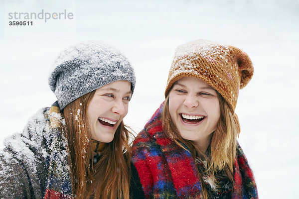 Zwei glückliche junge Frauen im Schnee