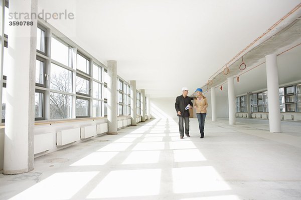 Zwei Architekten gehen durch die Baustelle