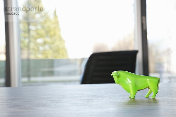 Grüner Stier auf dem Konferenztisch stehend