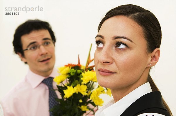 Frauen ignorieren den Mann  der Blumen anbietet.