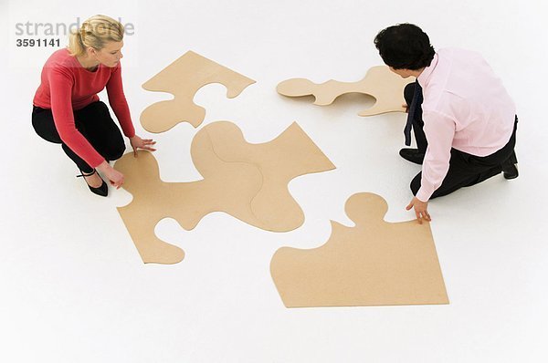 Geschäftsleute arbeiten am Finishing-Puzzle