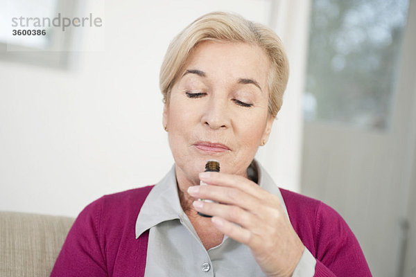 Nahaufnahme einer Frau  die Aromatherapieöl riecht