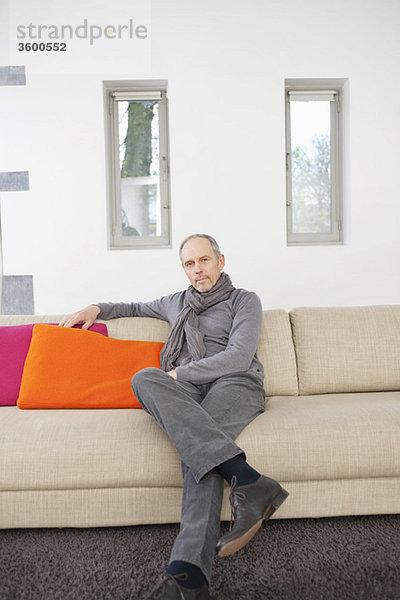 Porträt eines Mannes  der auf einer Couch sitzt