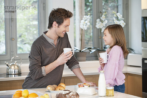 Mann trinkt Kaffee mit seiner Tochter