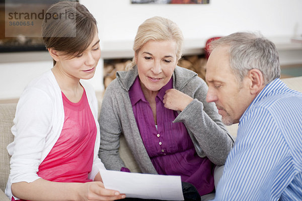 Mädchen beim Lesen eines Dokuments mit ihren Großeltern