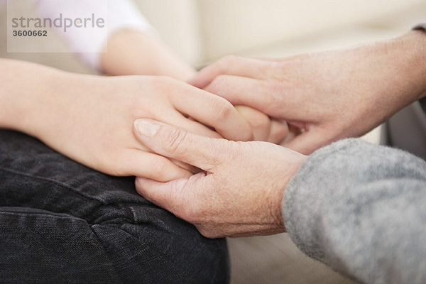 Frau hält die Hände ihrer Enkelin