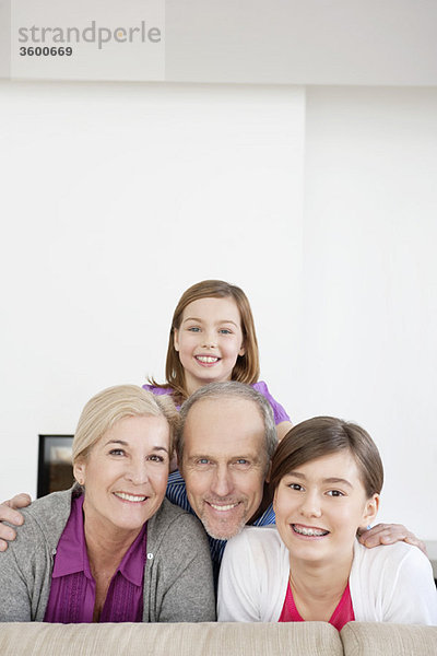 Ein Paar lächelt mit seinen Enkelinnen.