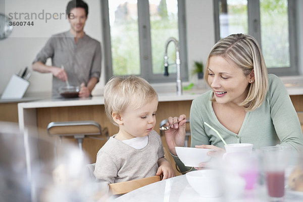 Frau füttert ihren Sohn mit Frühstück