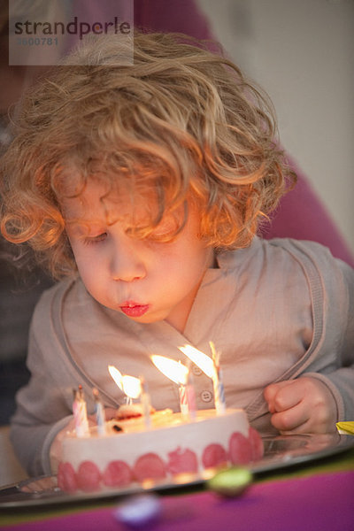 Junge  der Kerzen auf seinem Geburtstagskuchen ausbläst.