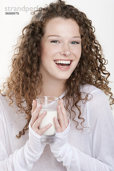 Porträt einer Frau  die ein Glas Milch hält und lacht
