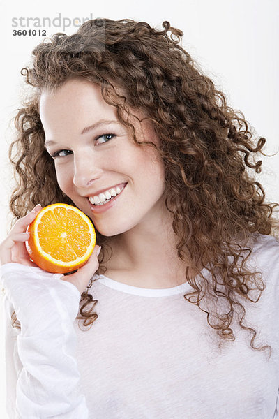 Porträt einer Frau mit einer halben Orange