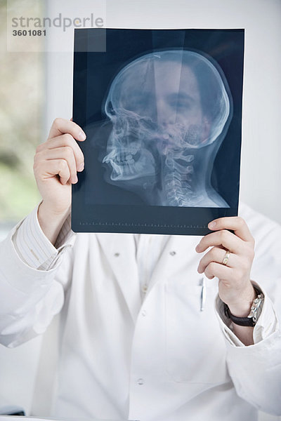 Männlicher Arzt bei der Untersuchung eines Röntgenbildes