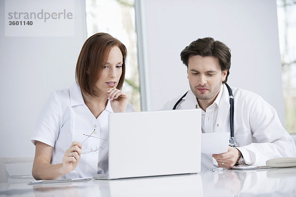 Ärzte  die an einem Laptop arbeiten