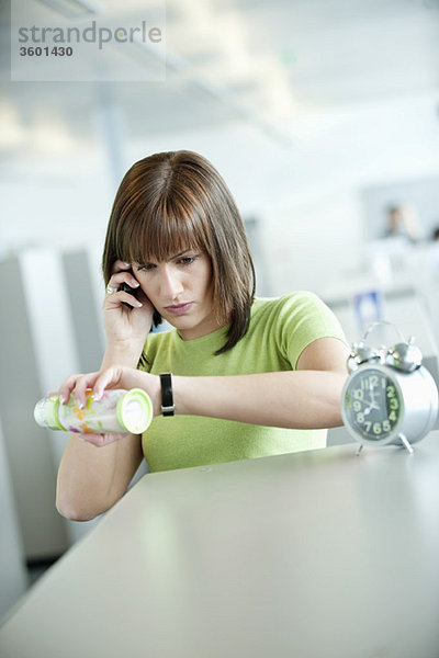 Geschäftsfrau im Gespräch mit dem Handy und Überprüfung der Uhrzeit