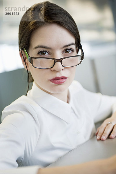Porträt einer Geschäftsfrau mit Blick über die Brille