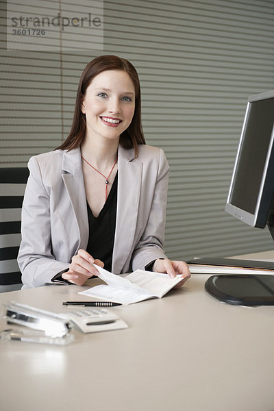 Geschäftsfrau  die Papierkram in einem Büro erledigt