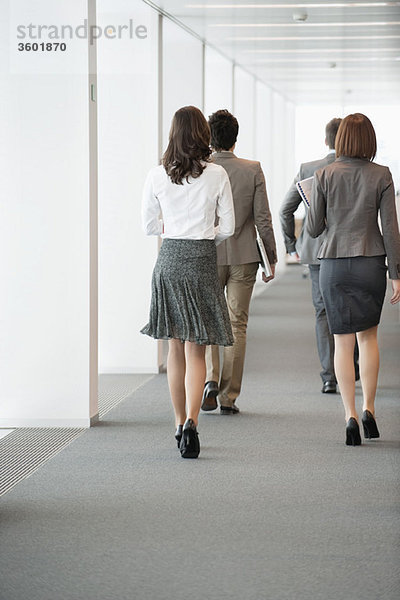 Geschäftsleute  die im Flur eines Büros spazieren gehen