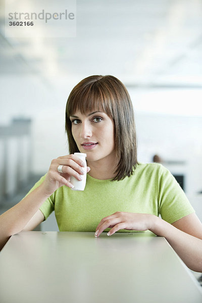 Porträt einer Geschäftsfrau  die probiotisches Getränk trinkt