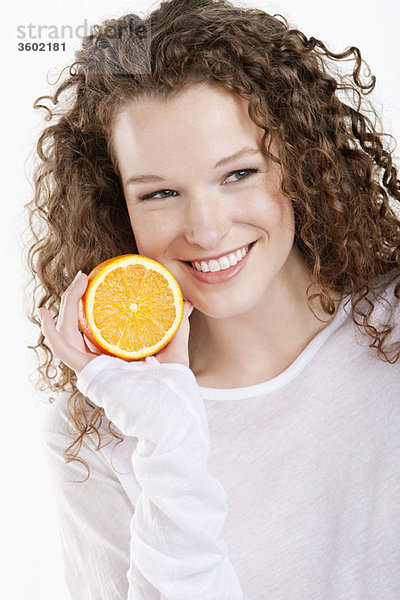 Nahaufnahme einer Frau mit einer halben Orange