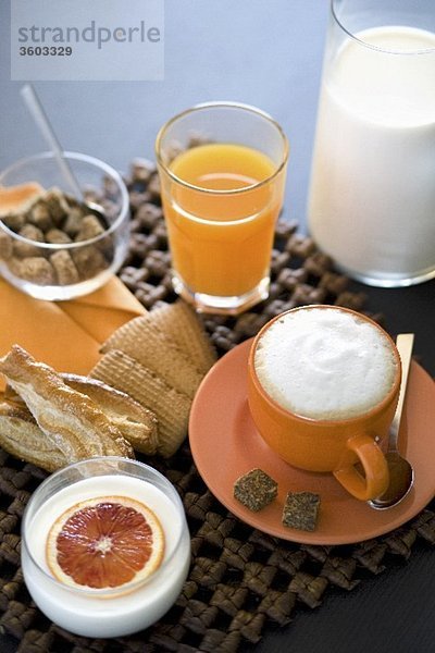 Italienisches Frühstück mit Saft  Cappuccino  Joghurt und Keksen