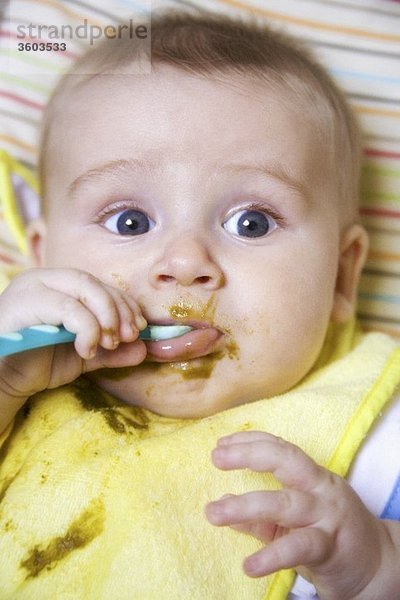 Baby isst Brei mit Löffel