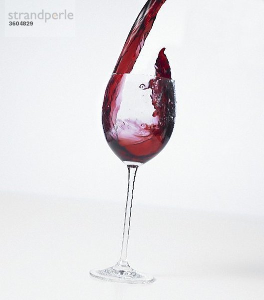 Rotwein in ein Glas giessen (Splash)