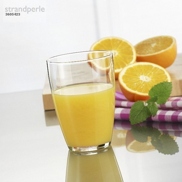 Glas Orangensaft und frische Orangen