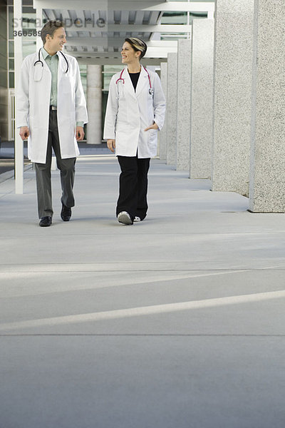 Ärzte plaudern und gehen gemeinsam den Krankenhausflur entlang