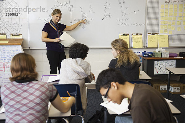Frau unterrichtet Mathematik an Gymnasiasten