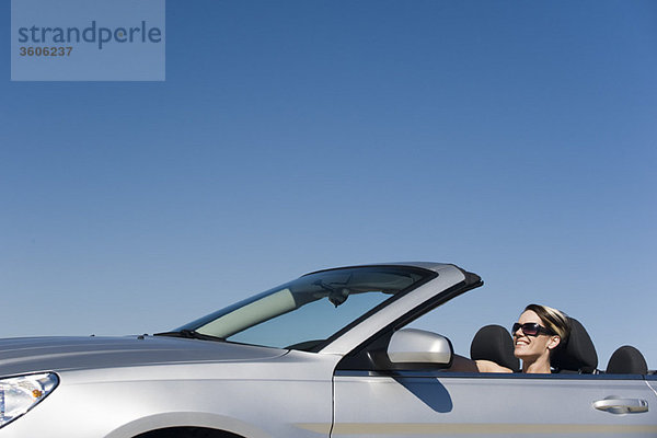 Frau auf Vergnügungsfahrt im Cabriolet