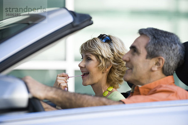 Erwachsenes Paar im Auto zusammen  Frau mit Lipgloss