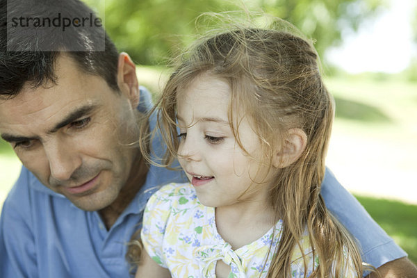 Vater und kleine Tochter reden im Freien