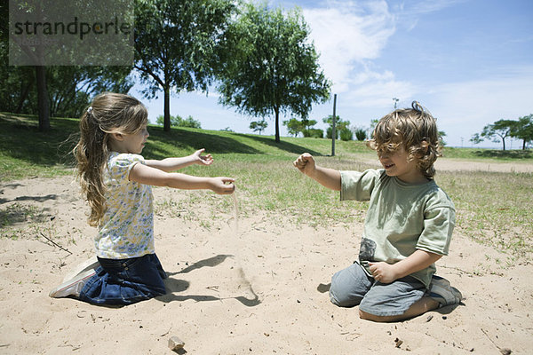 Kleine Kinder beim Spielen im Sand im Park