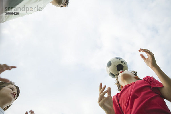 Vater und Söhne beim Fußballspielen  Tiefblick