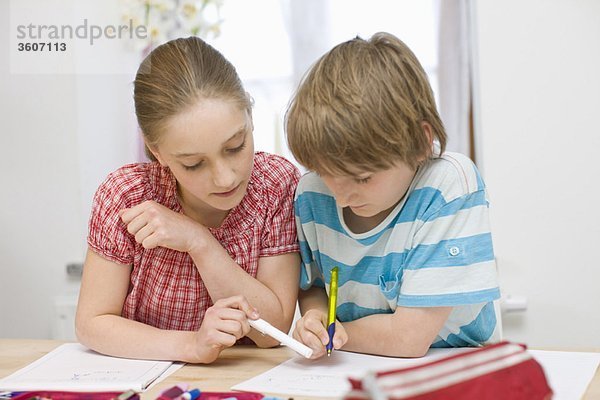 Junge und Mädchen bei den Hausaufgaben