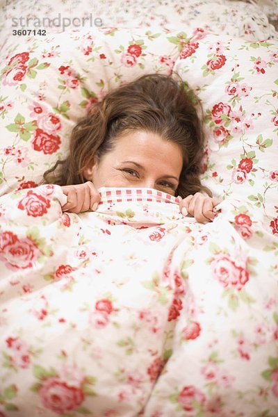 Frau versteckt sich im Bett